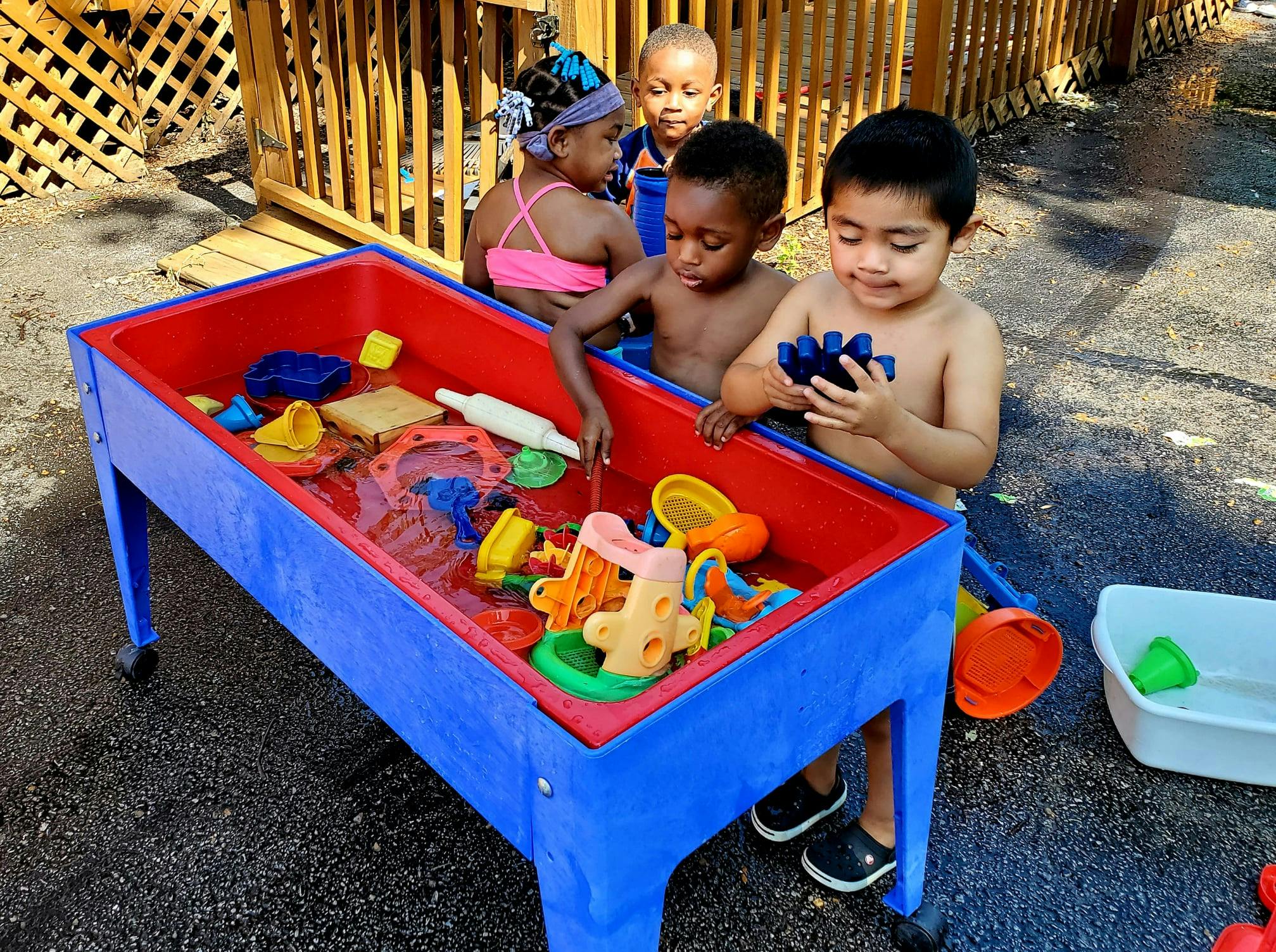 Children playing with toys in a water table