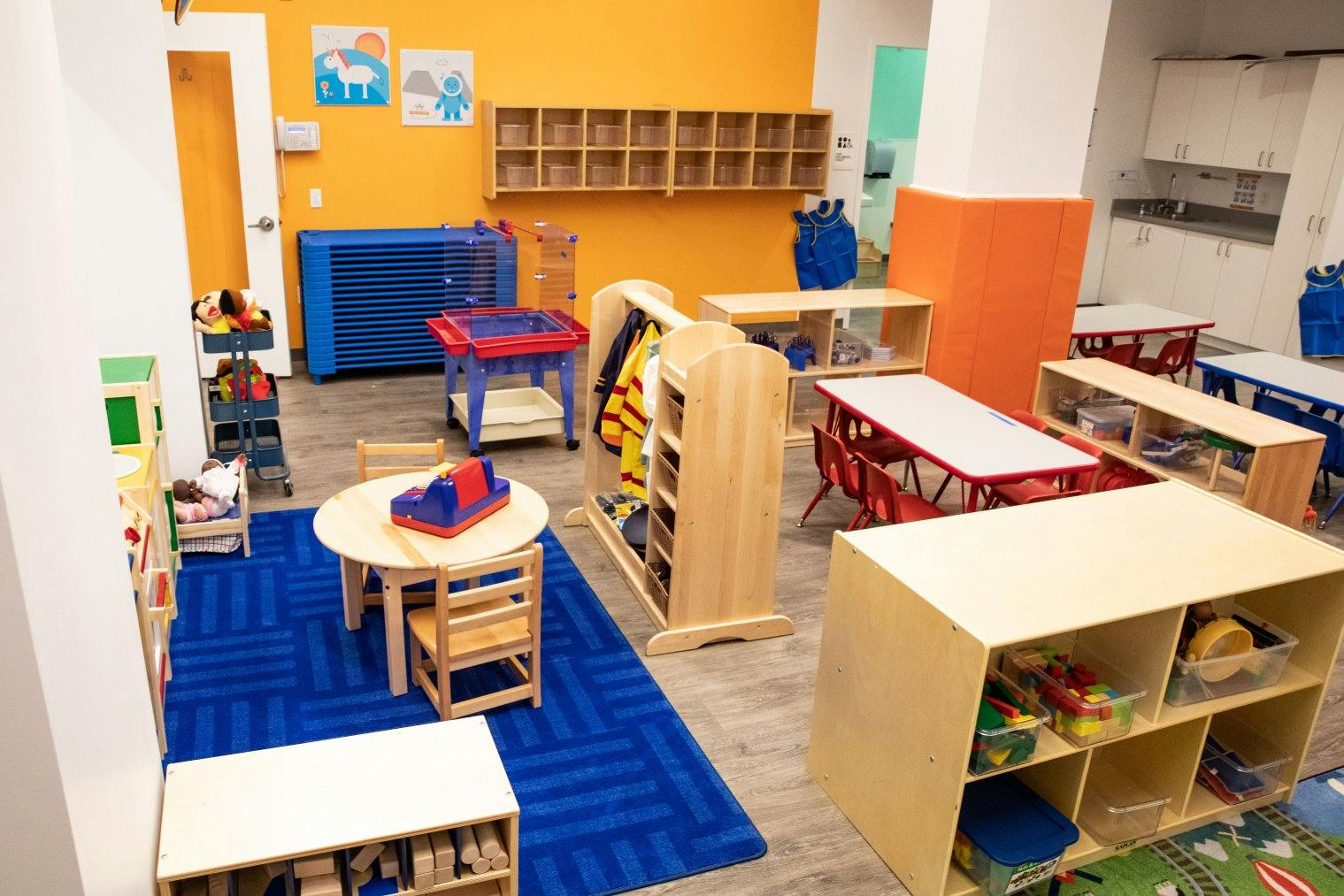 An empty early childhood classroom with colorful furniture and toys