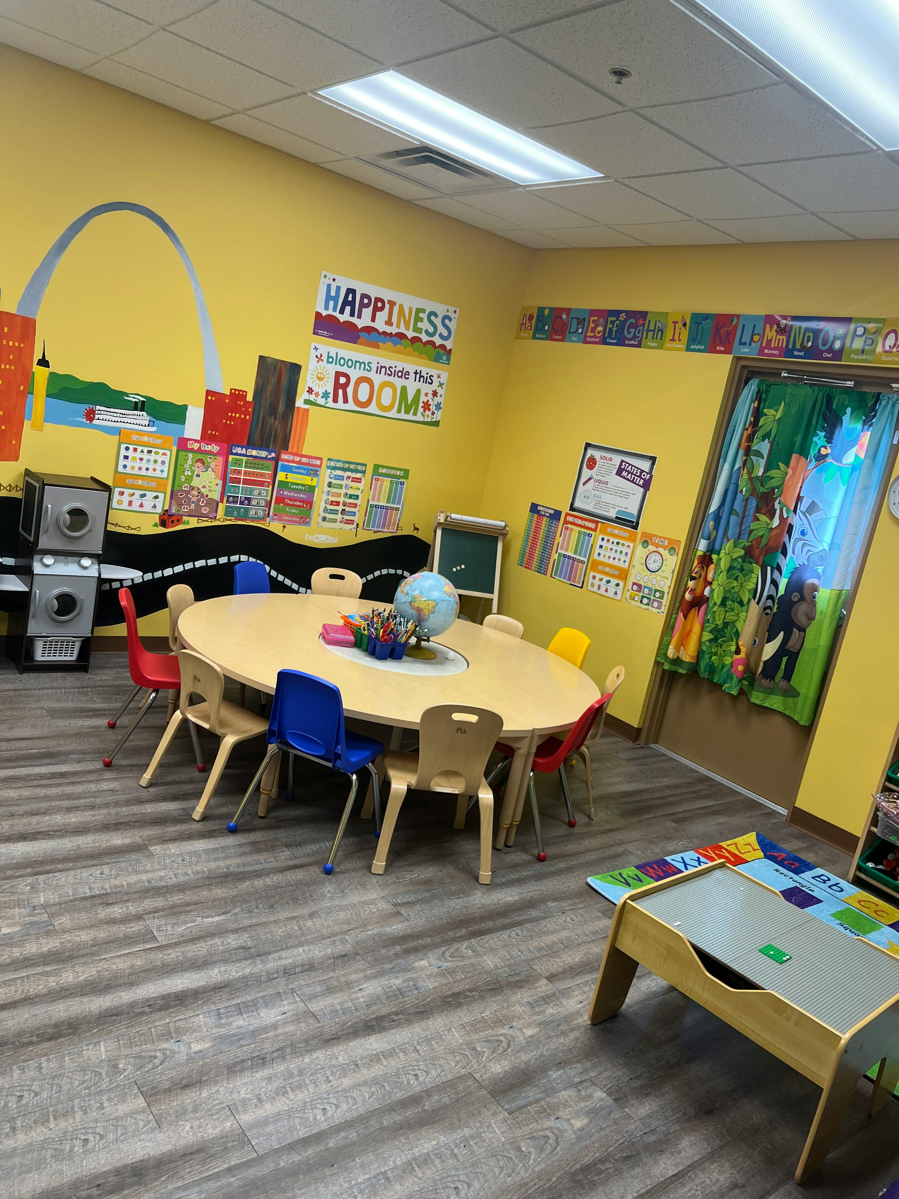 Classroom with a large oval table and chairs, colorful wall decorations
