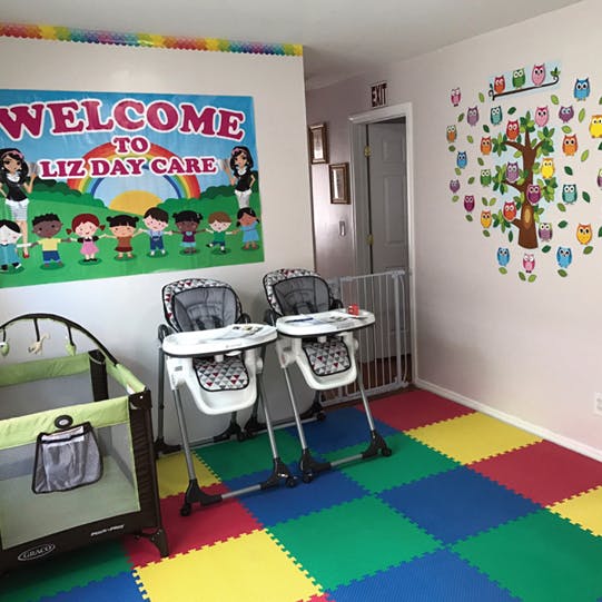 Daycare room with a crib, two high chairs, and a welcome sign