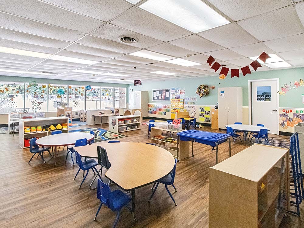 Empty classroom with small tables and chairs