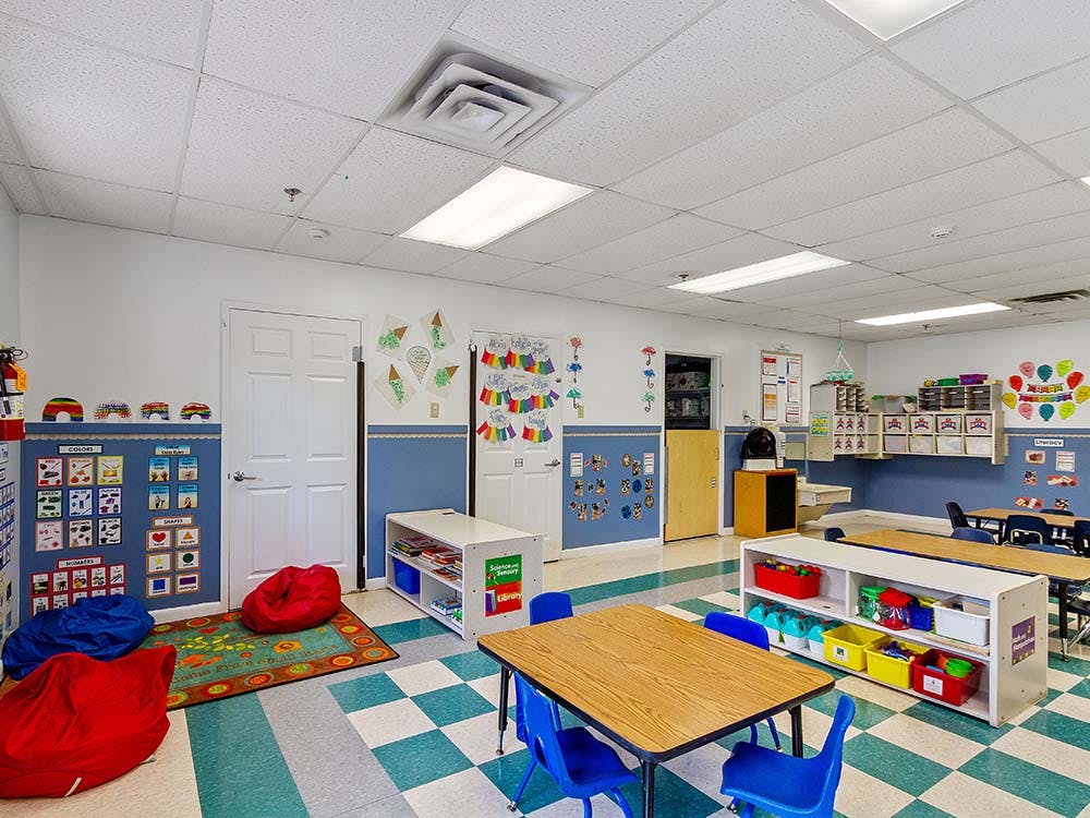 Classroom with tables, chairs, colorful beanbags, and learning posters