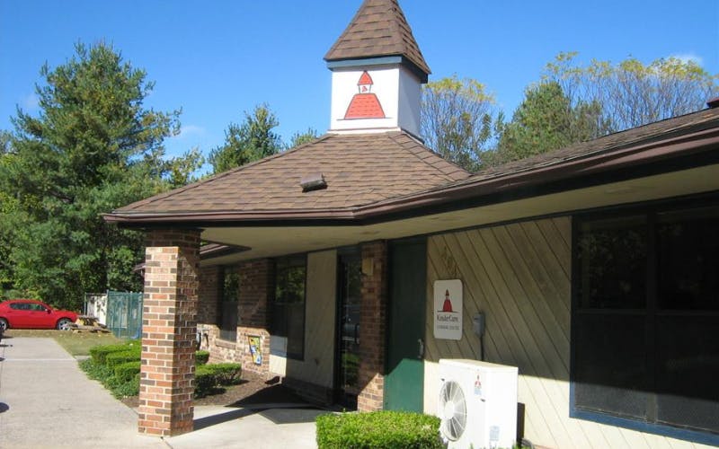 Exterior of a building with a small bell tower on the roof and a KinderCare sign