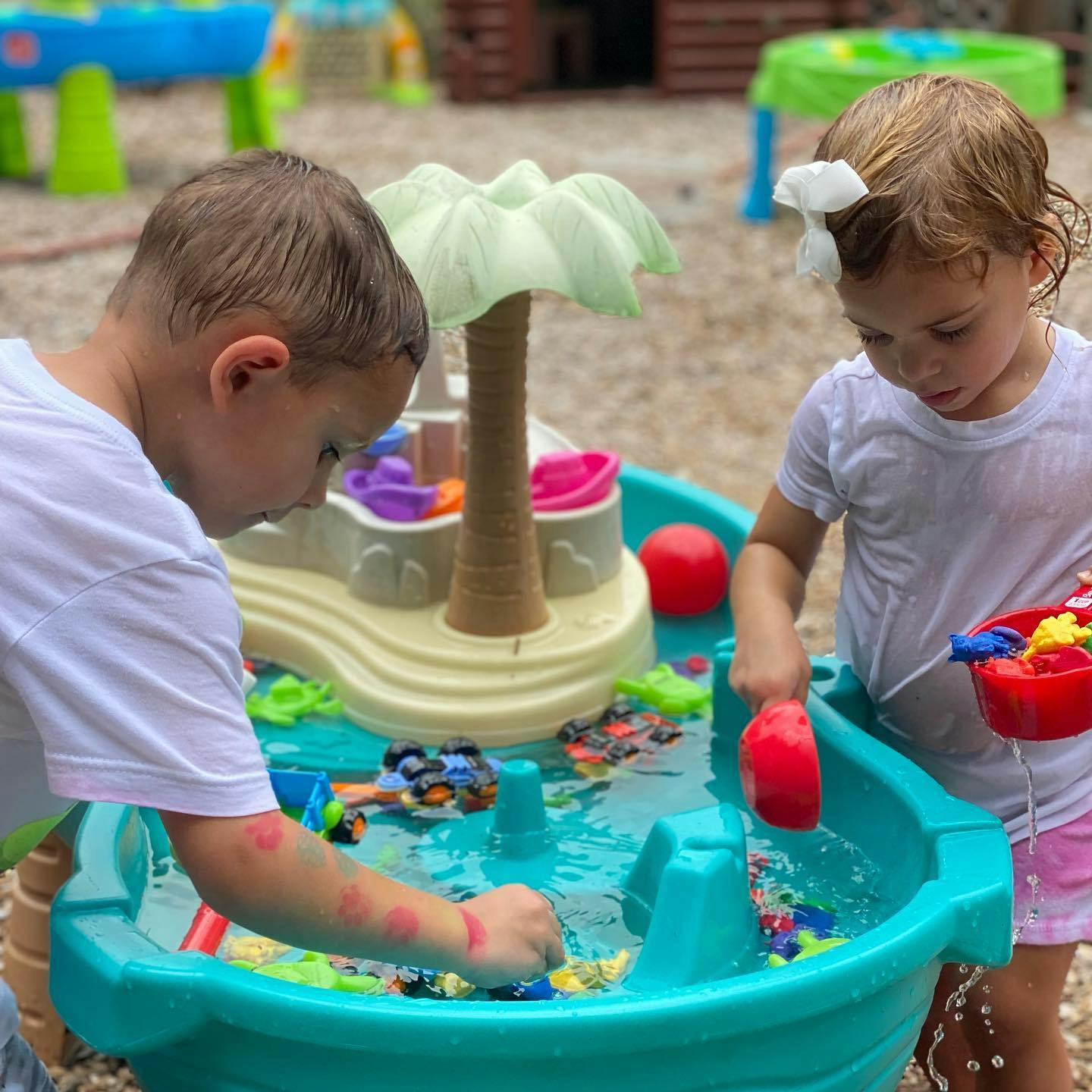 Two children playing with a water table