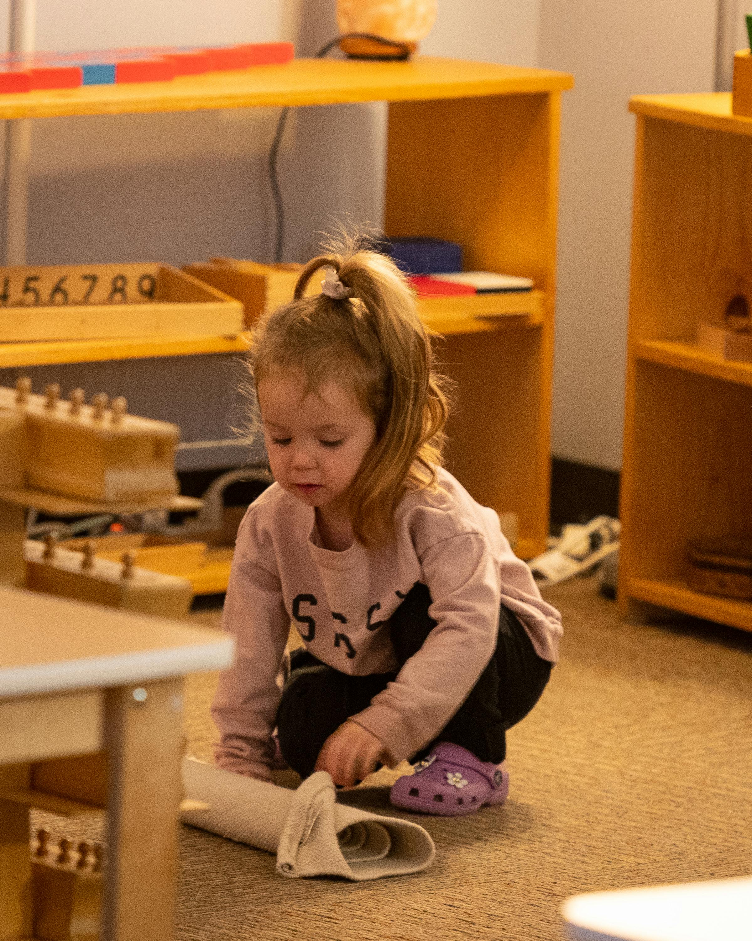 Child crouching on floor, interacting with an object
