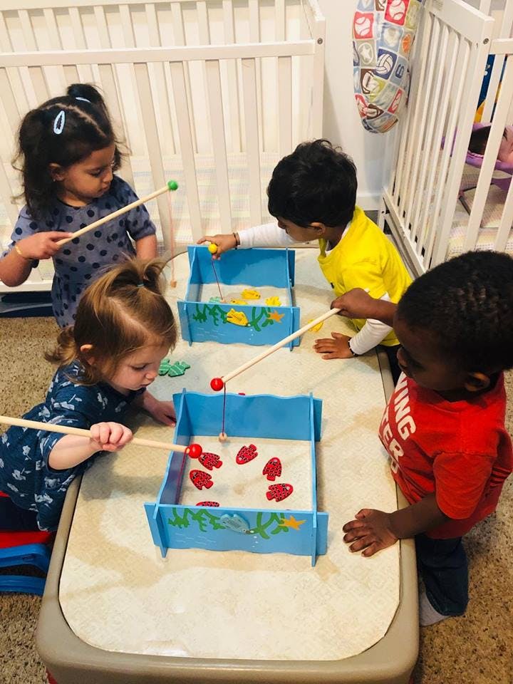 Four children playing with fishing toys at a table