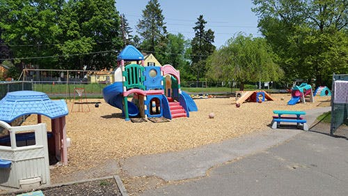 Playground with multiple colorful play structures and wood chips on the ground