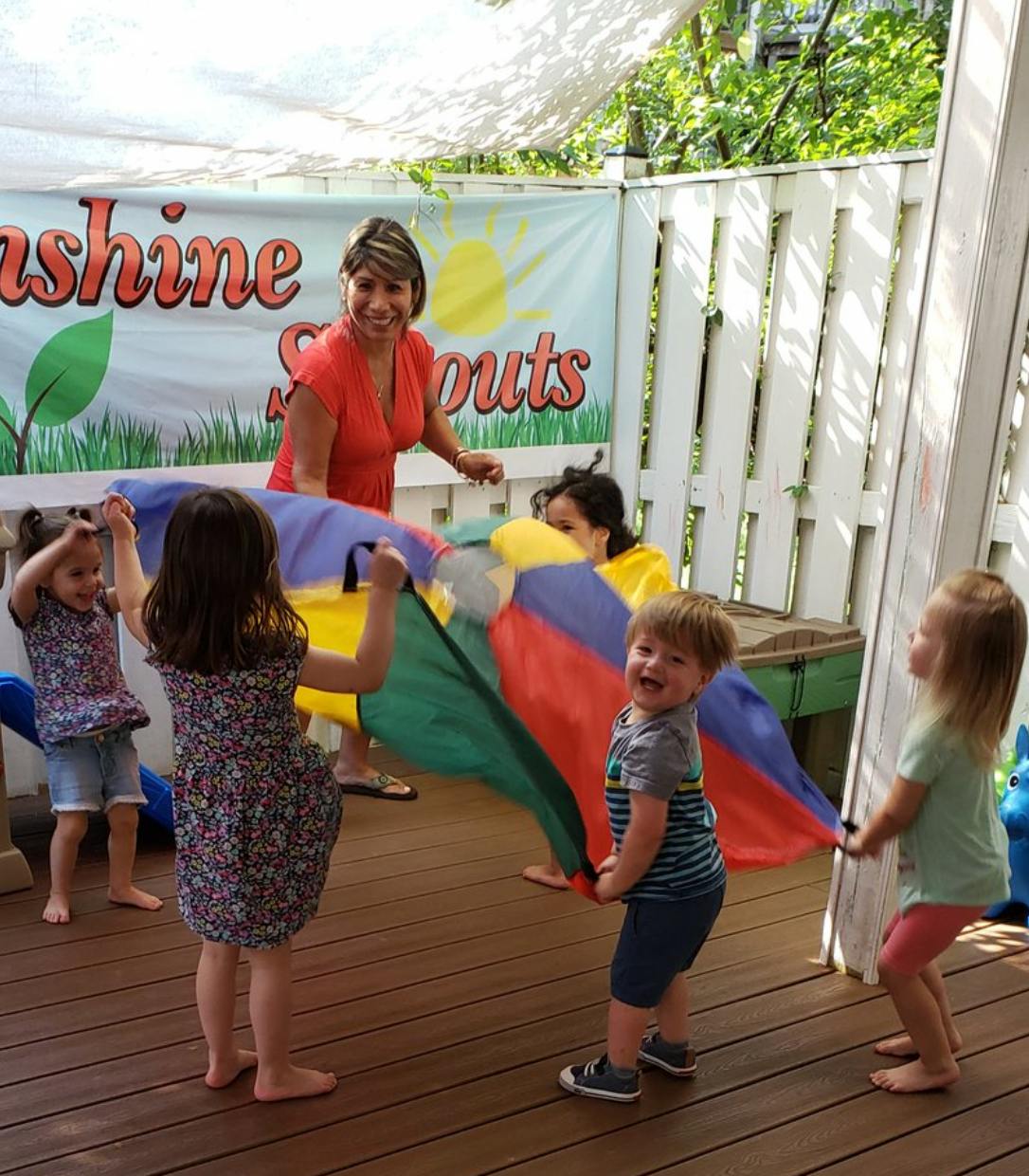 Adults and children playing with a colorful parachute