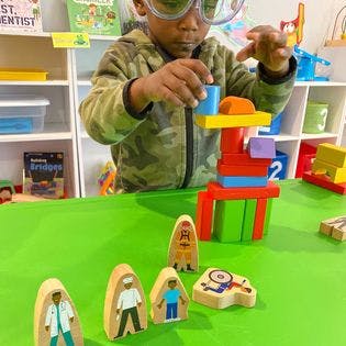 Child wearing goggles playing with colorful building blocks