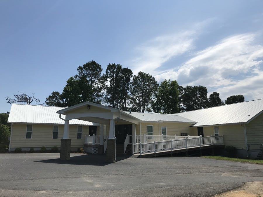 Building with a covered entrance and a long ramp leading to a doorway
