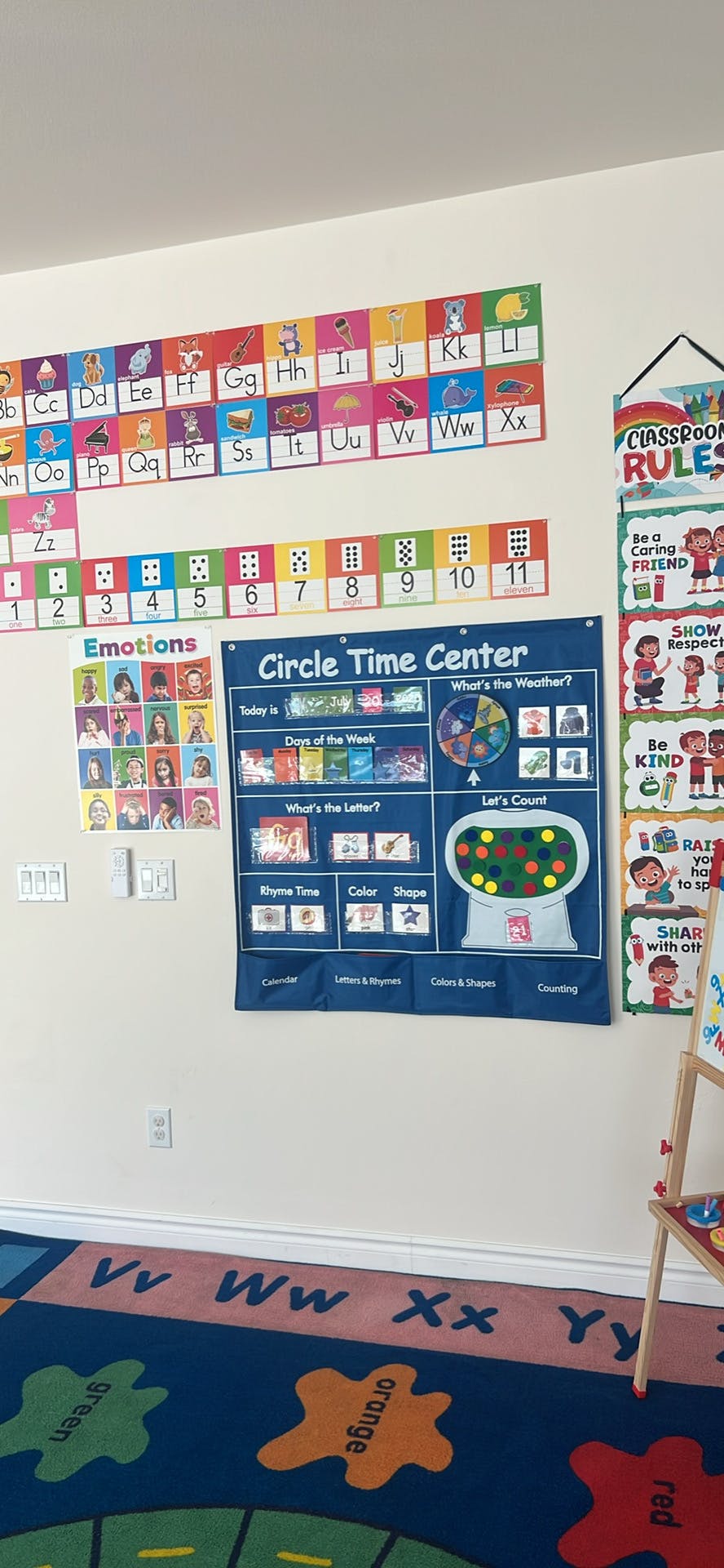 Colorful educational charts and a learning rug in a classroom