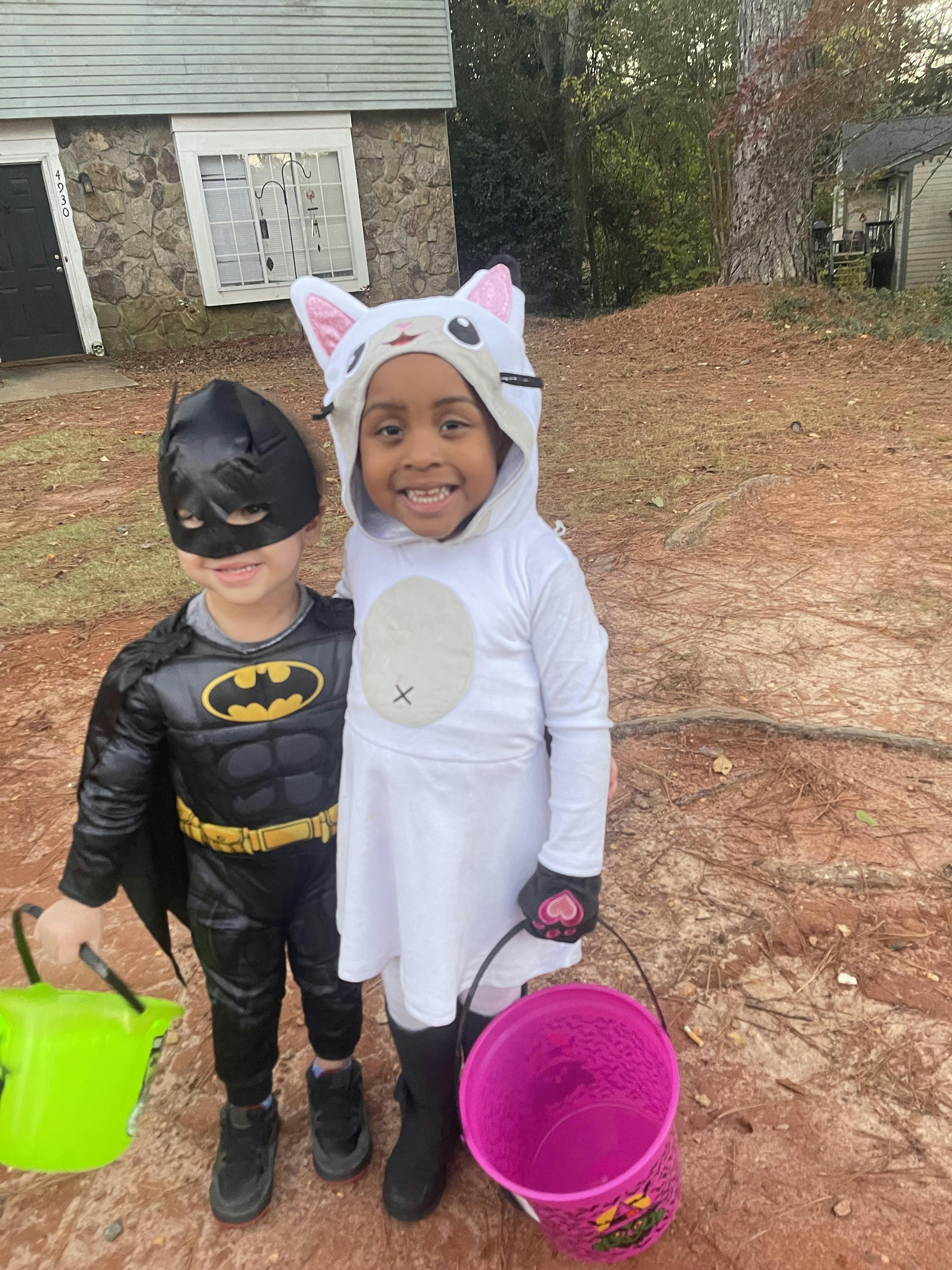 Two children in costumes holding buckets