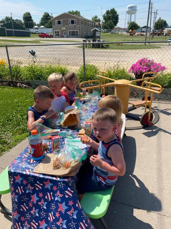 Children eating at a picnic table outdoors