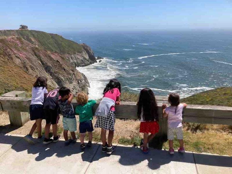 Children looking out at the ocean from a cliffside