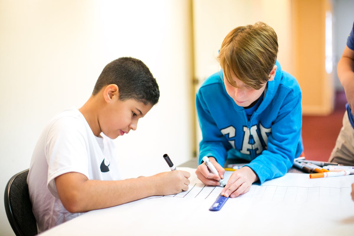 Two children drawing at a table