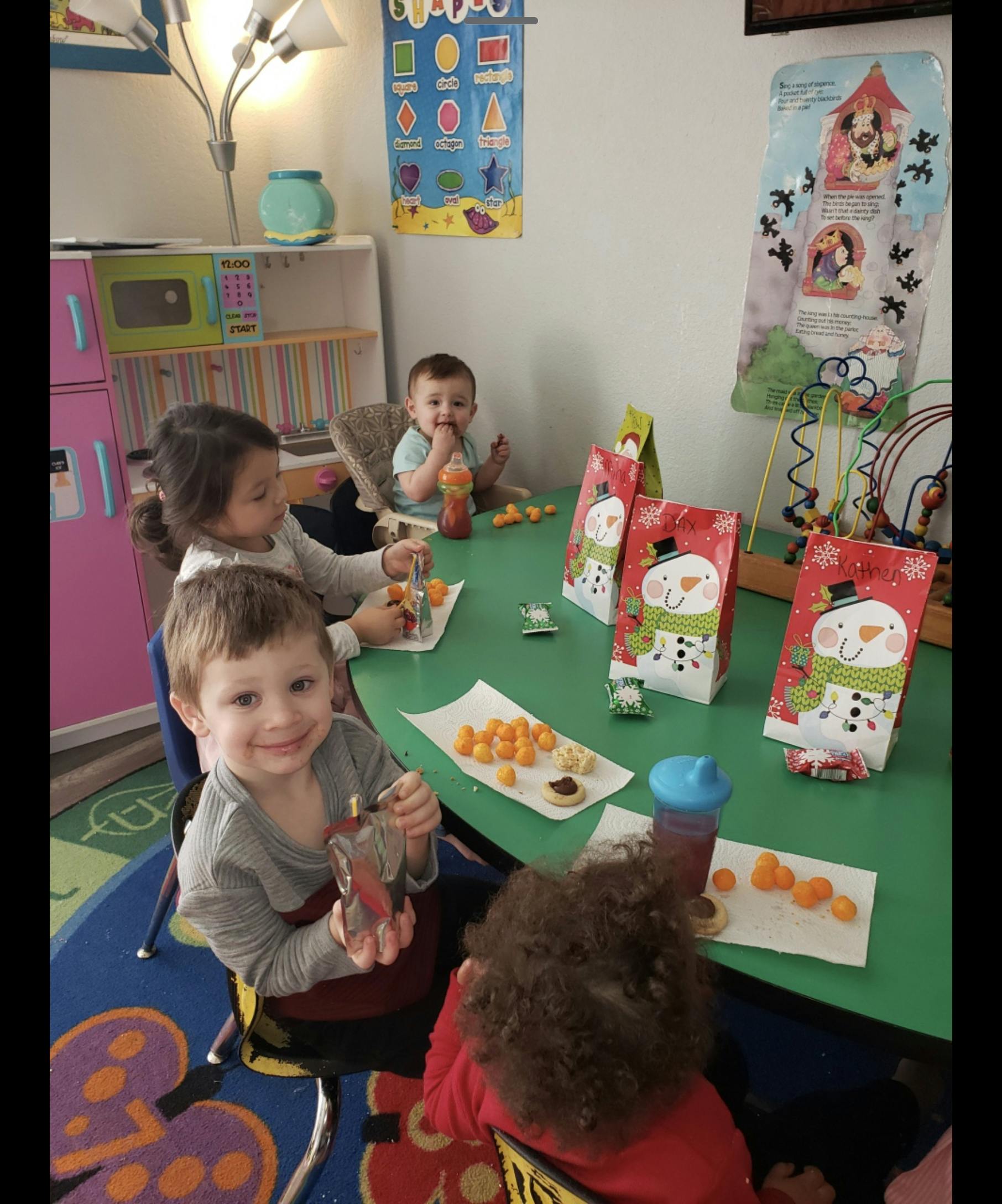 Children sitting at a table with snacks and gift bags