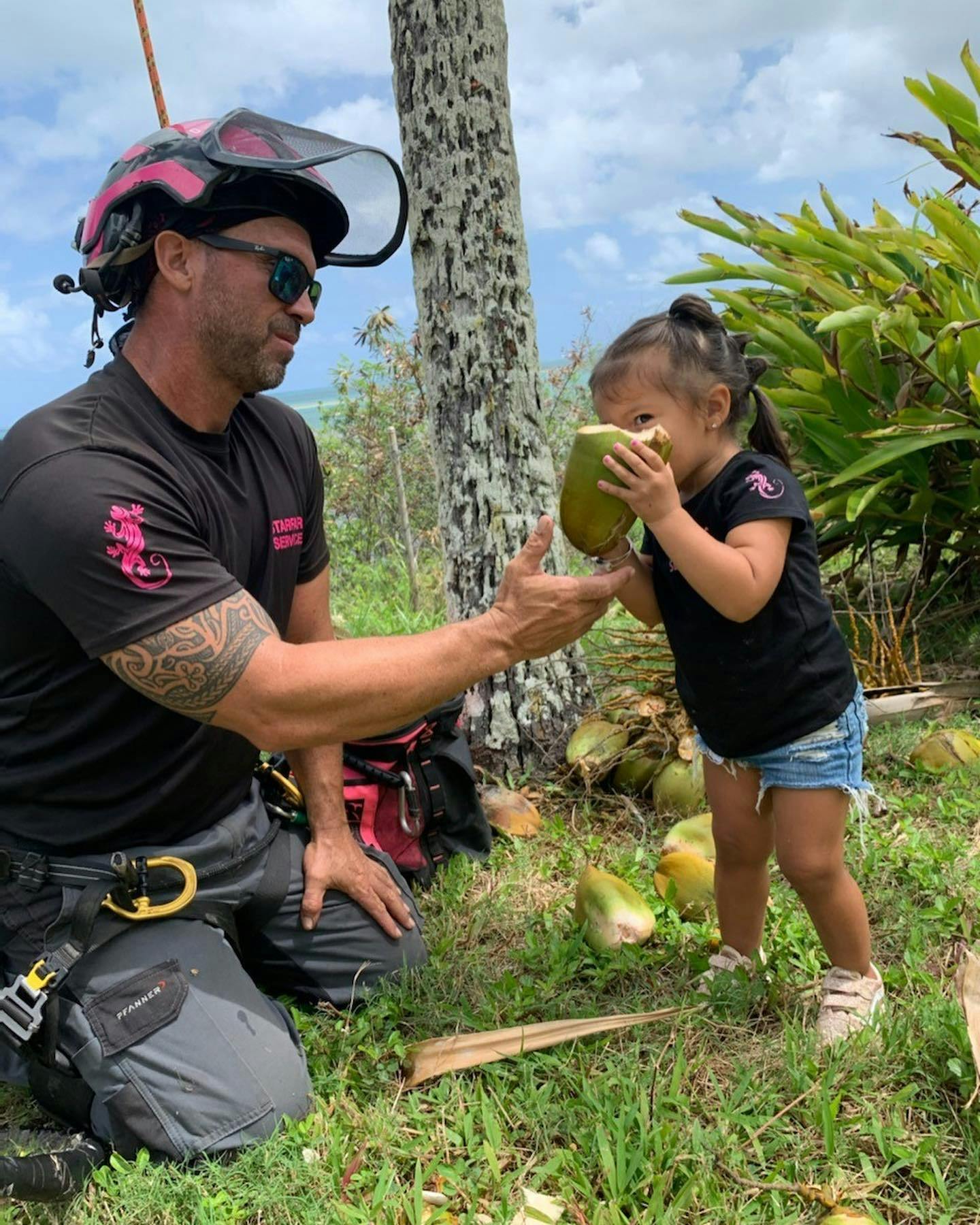 Person in safety gear handing a coconut to a child