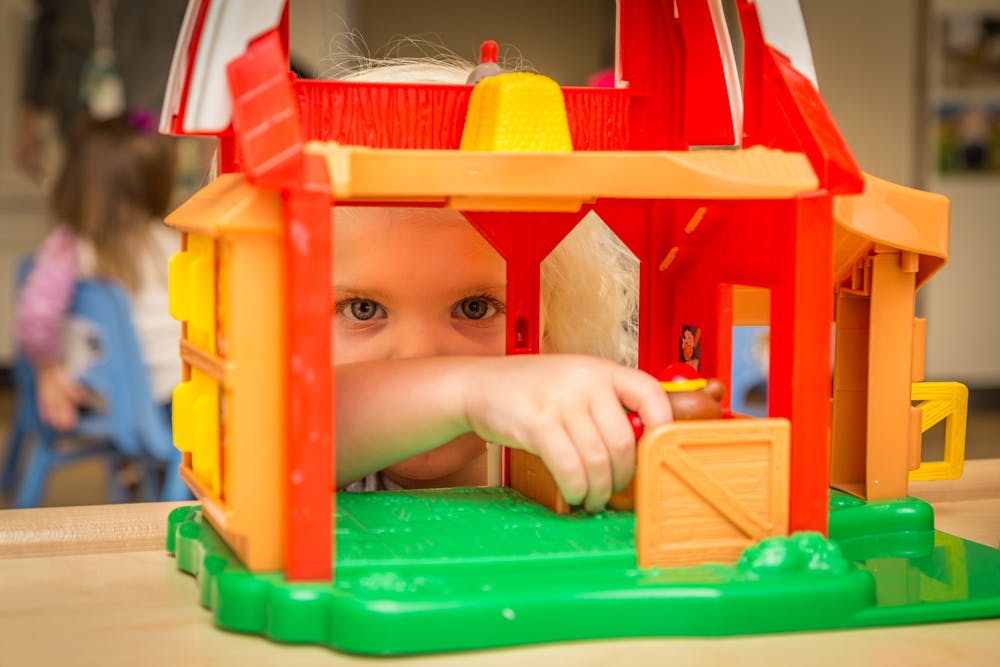 Child playing with a toy barn