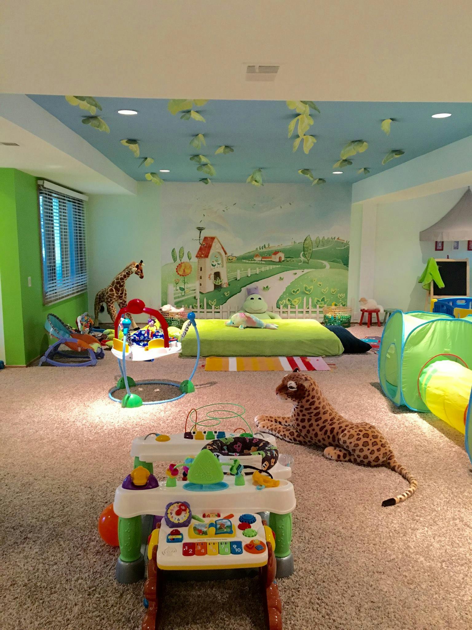 Playroom with various toys, a mural, and a leopard stuffed animal