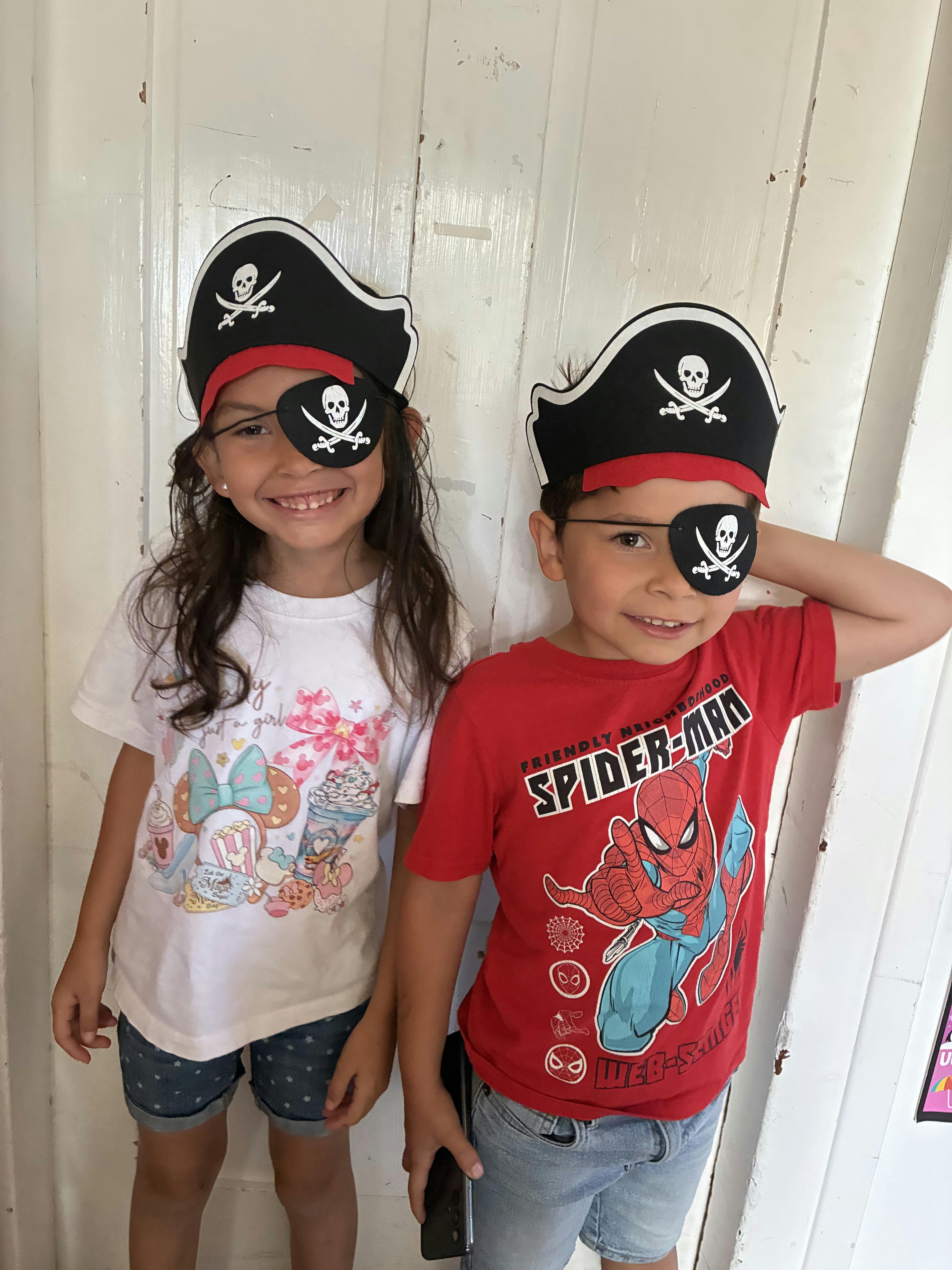 Two children wearing pirate hats and eye patches