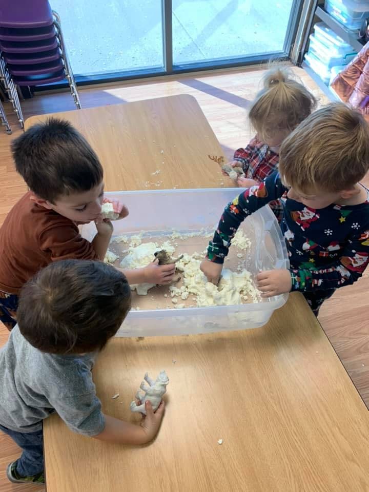 Children playing with sensory bin at a table