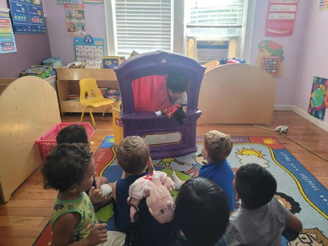 Group of children watching a puppet show in a classroom