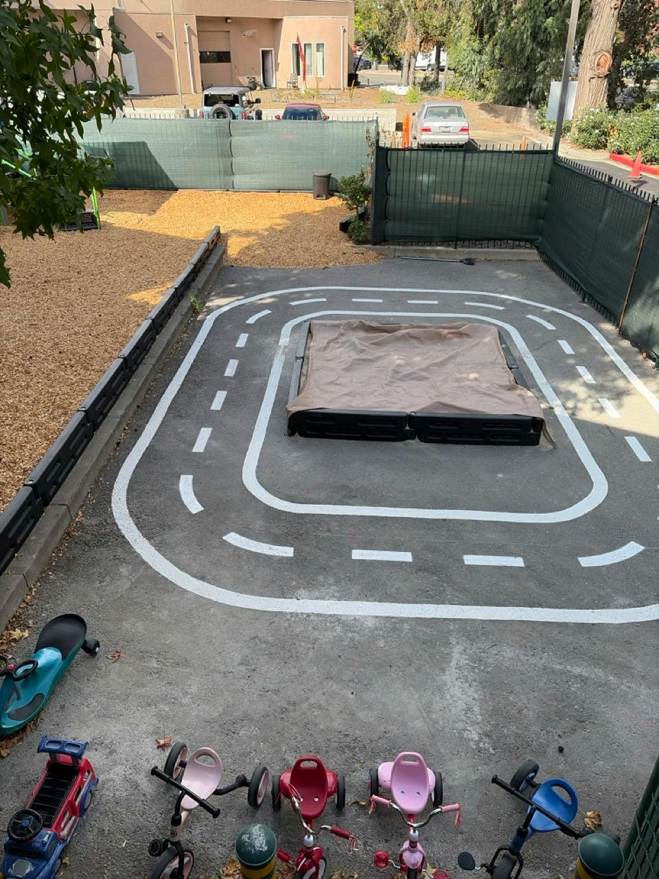 Playground area with a painted road loop and covered sandbox