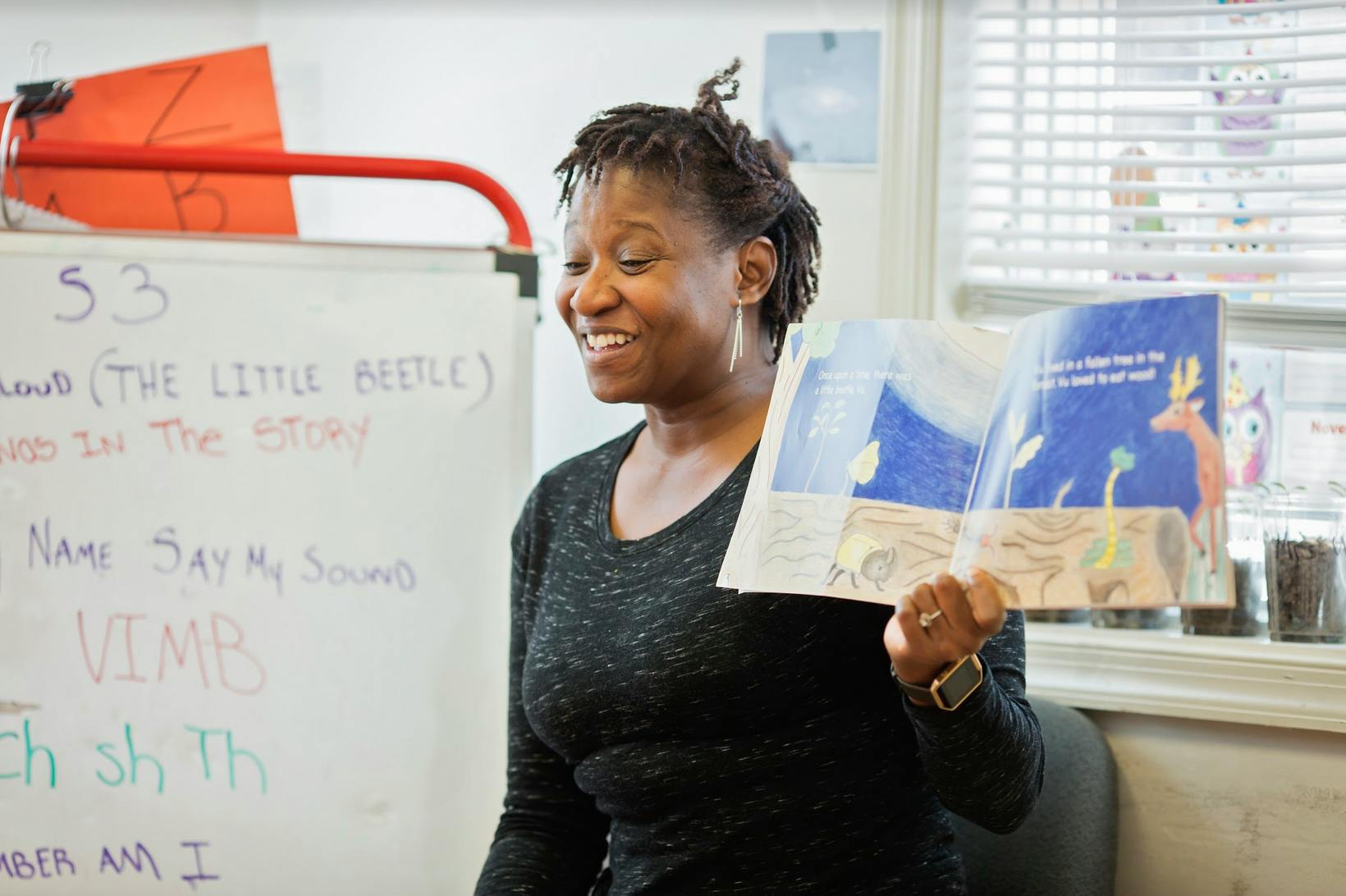 Person holding an open book with illustrations