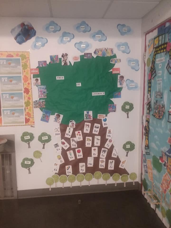 Wall decoration of a tree with cards on its trunk and leaves, clouds above