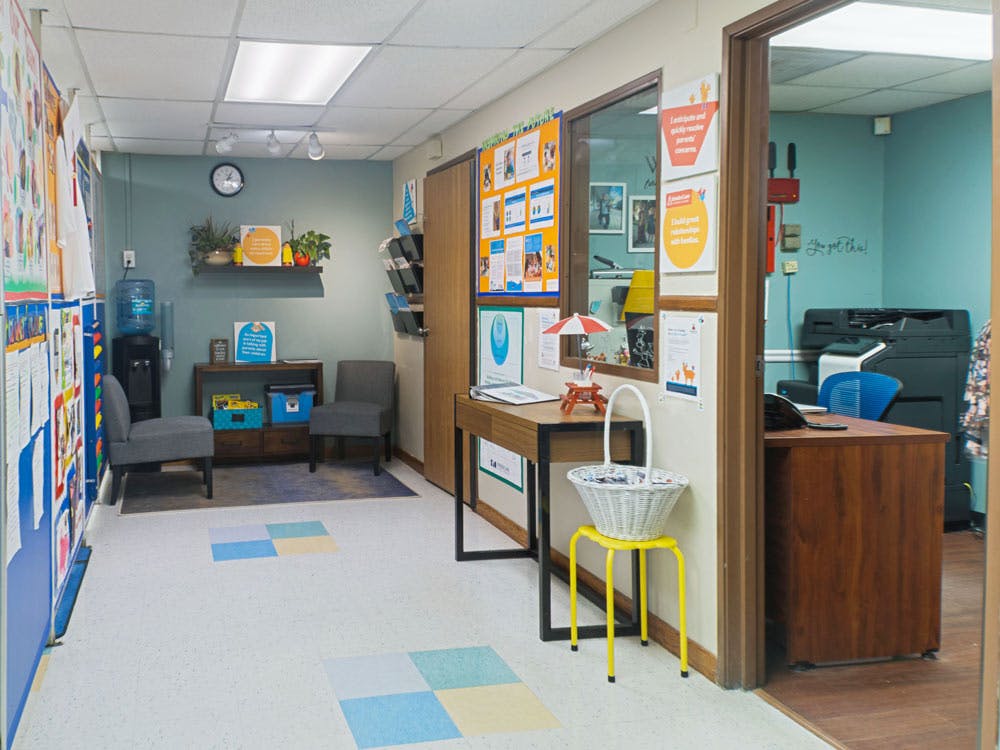 waiting area with two chairs, water cooler, and desk