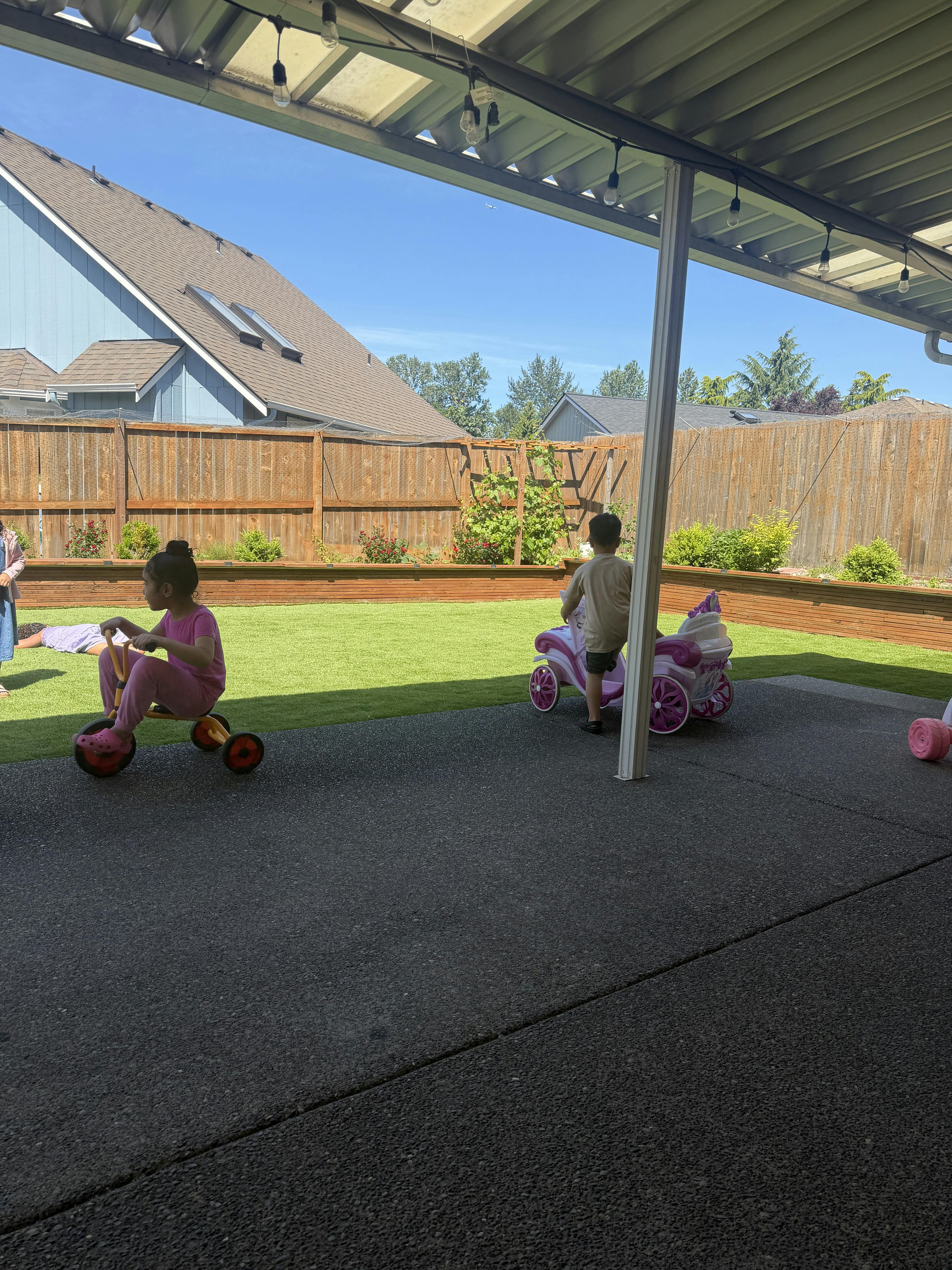Children playing with toy vehicles on a patio