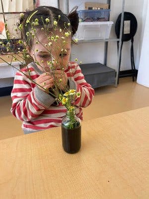 Child arranging flowers in a vase on a table