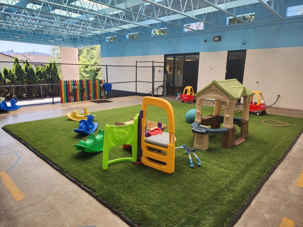 Outdoor children's play area with artificial grass and play equipment
