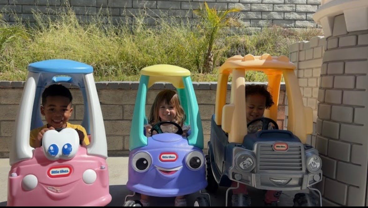 Three children in toy cars