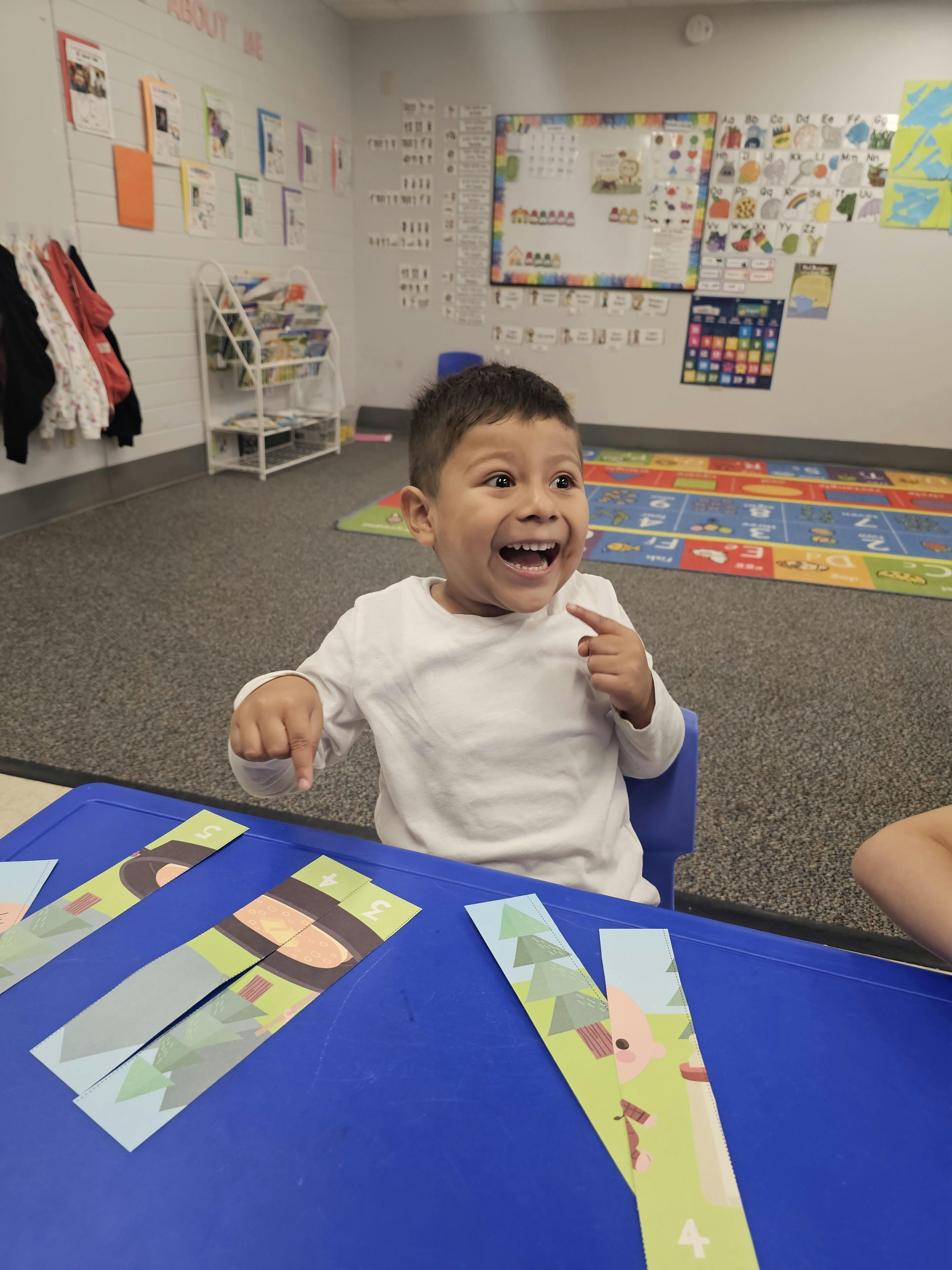 Child sitting at a table with paper crafts