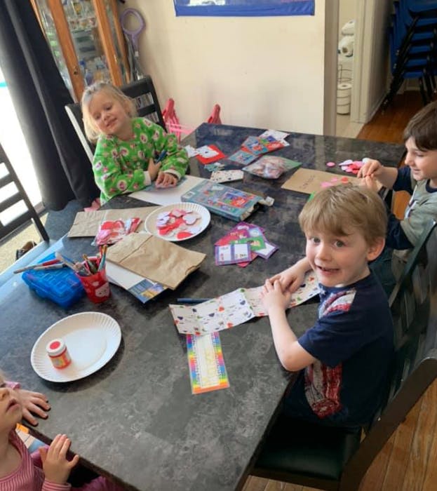Children sitting at a table with craft supplies