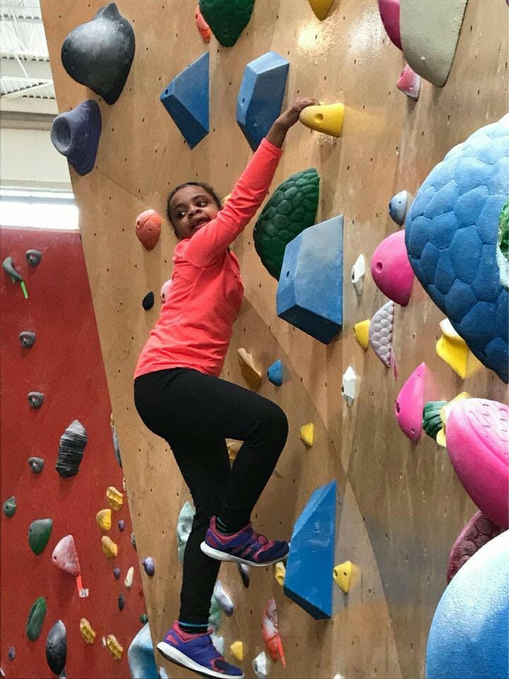 Child climbing an indoor rock wall