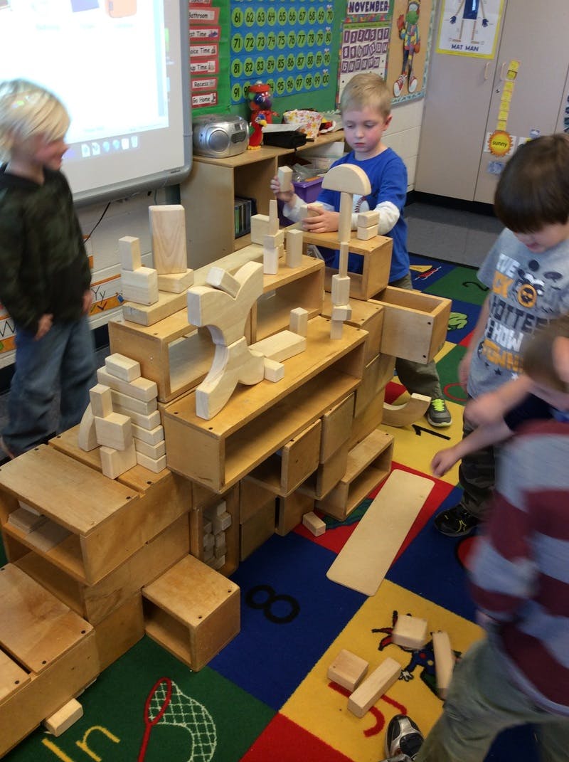 Children playing with wooden blocks in a classroom