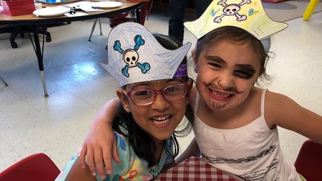 Two children in pirate hats, one with face paint