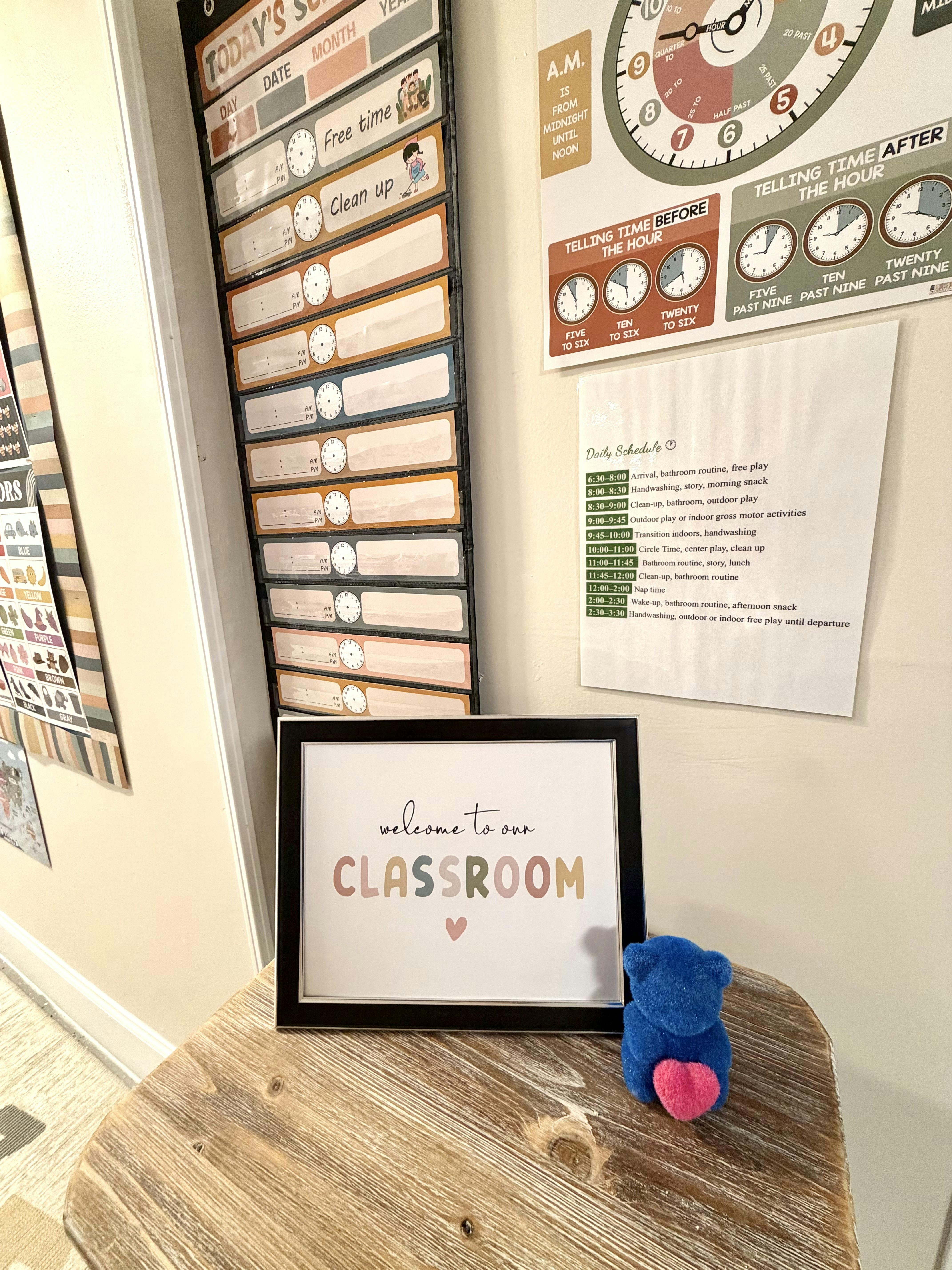 Framed sign with "welcome to our CLASSROOM" text on a wooden surface
