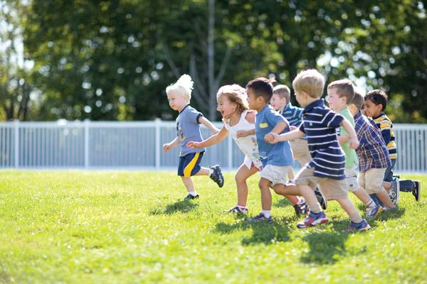 Group of children running on grass