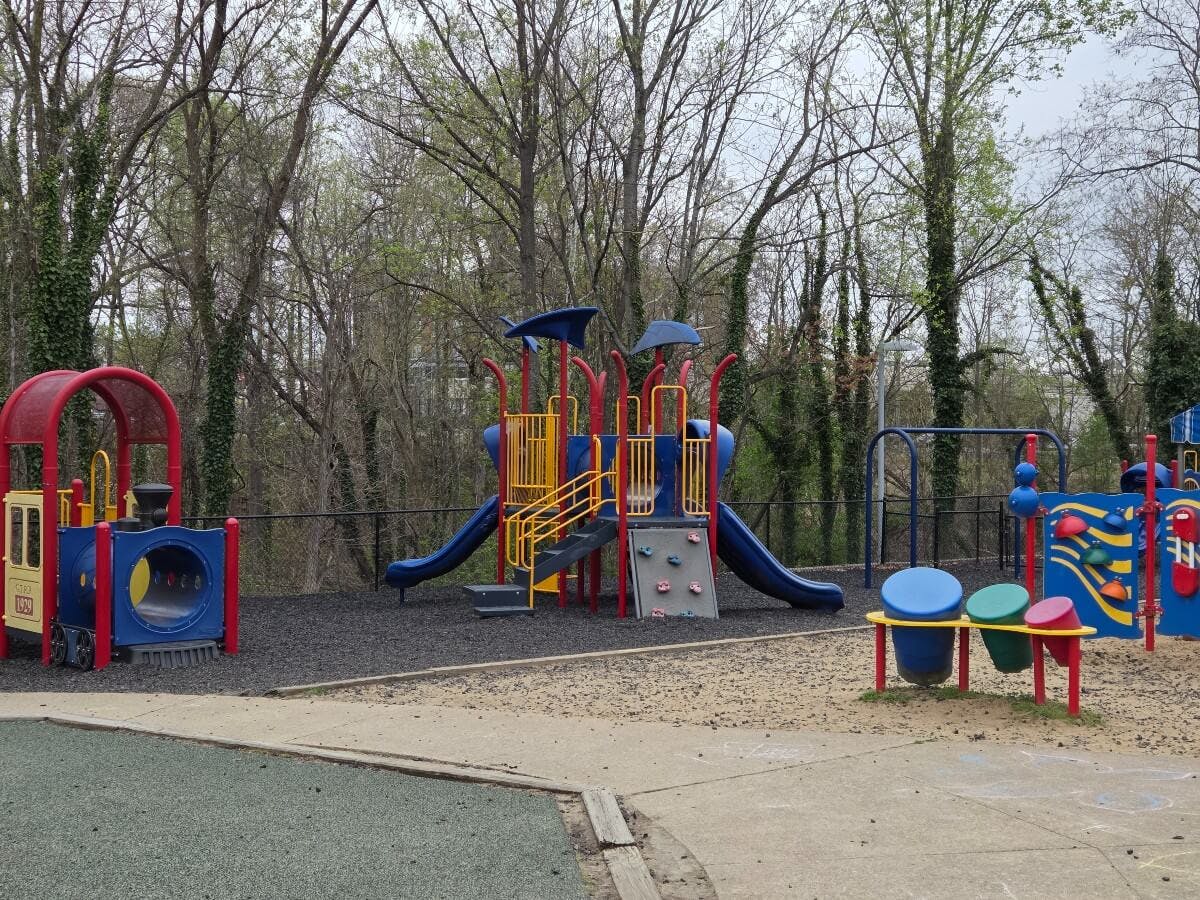 Colorful playground with a train structure, slides, and musical play equipment