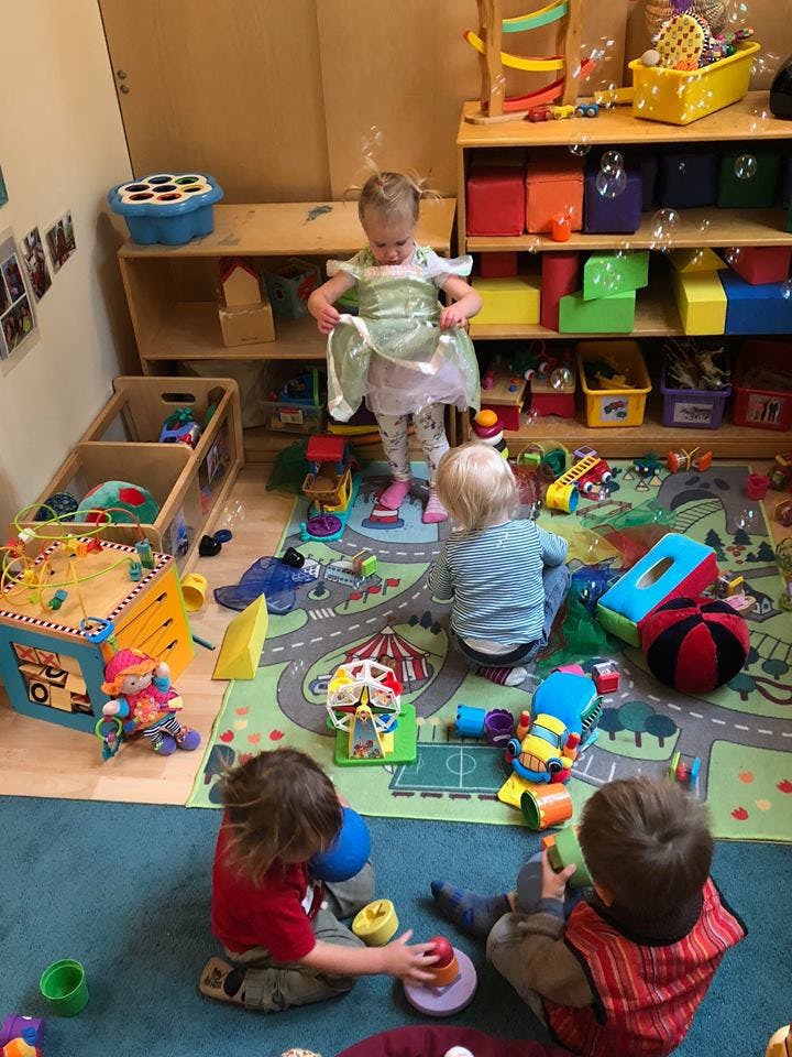 Children playing with toys on a rug in a room