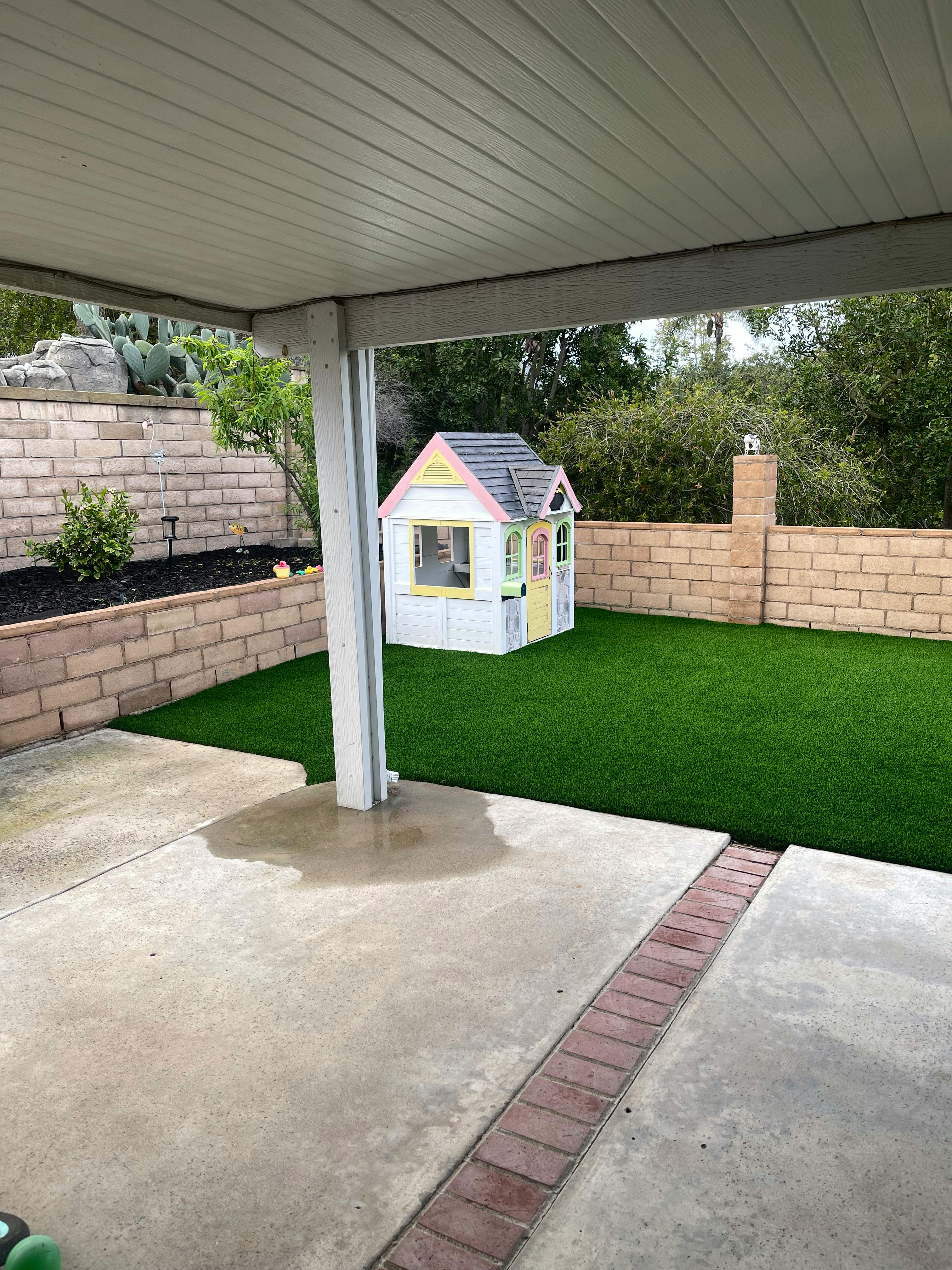 Backyard with artificial turf and a small playhouse