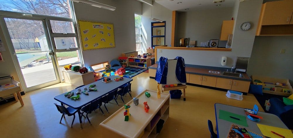 Empty classroom with tables, chairs, and toys
