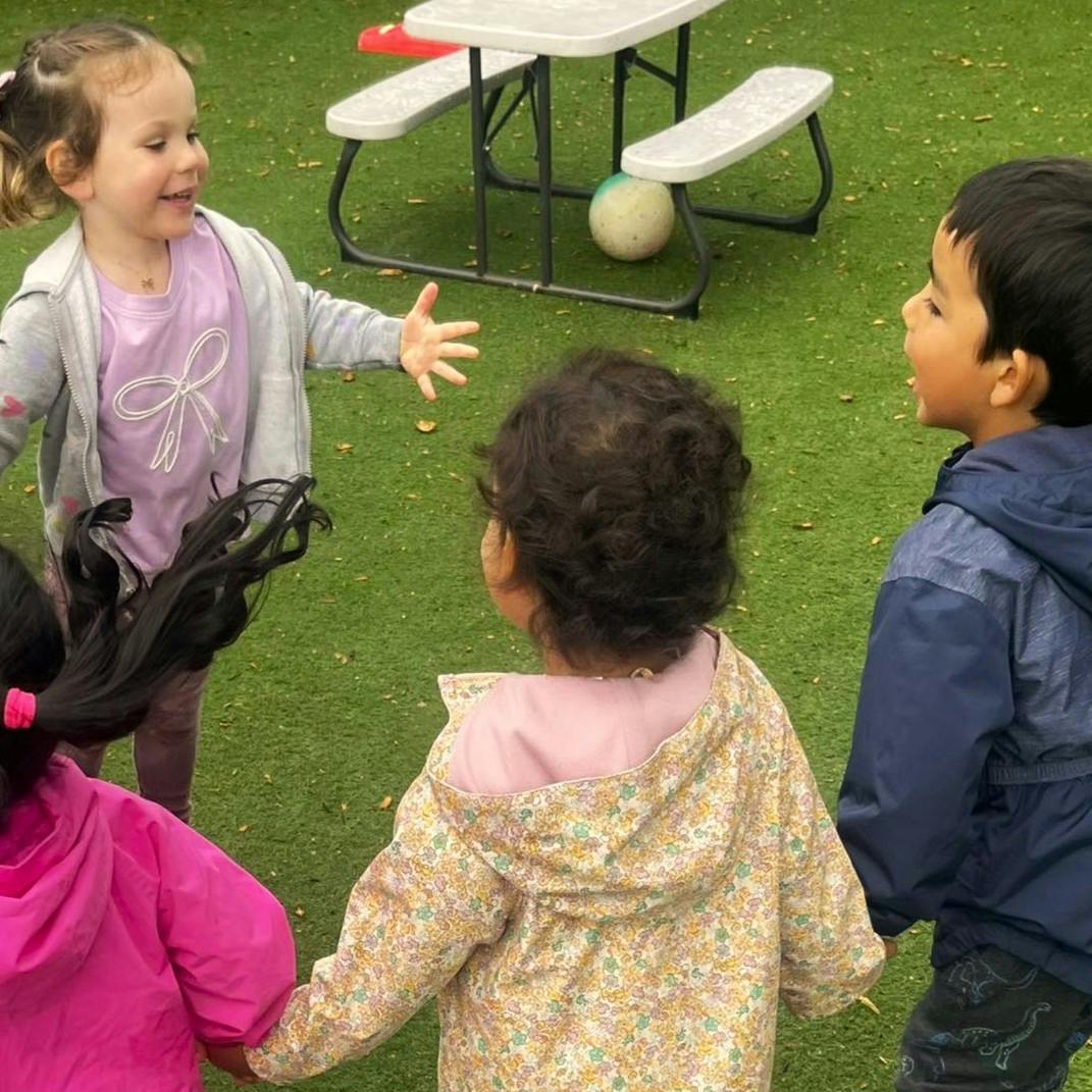 Four children playing together on artificial grass