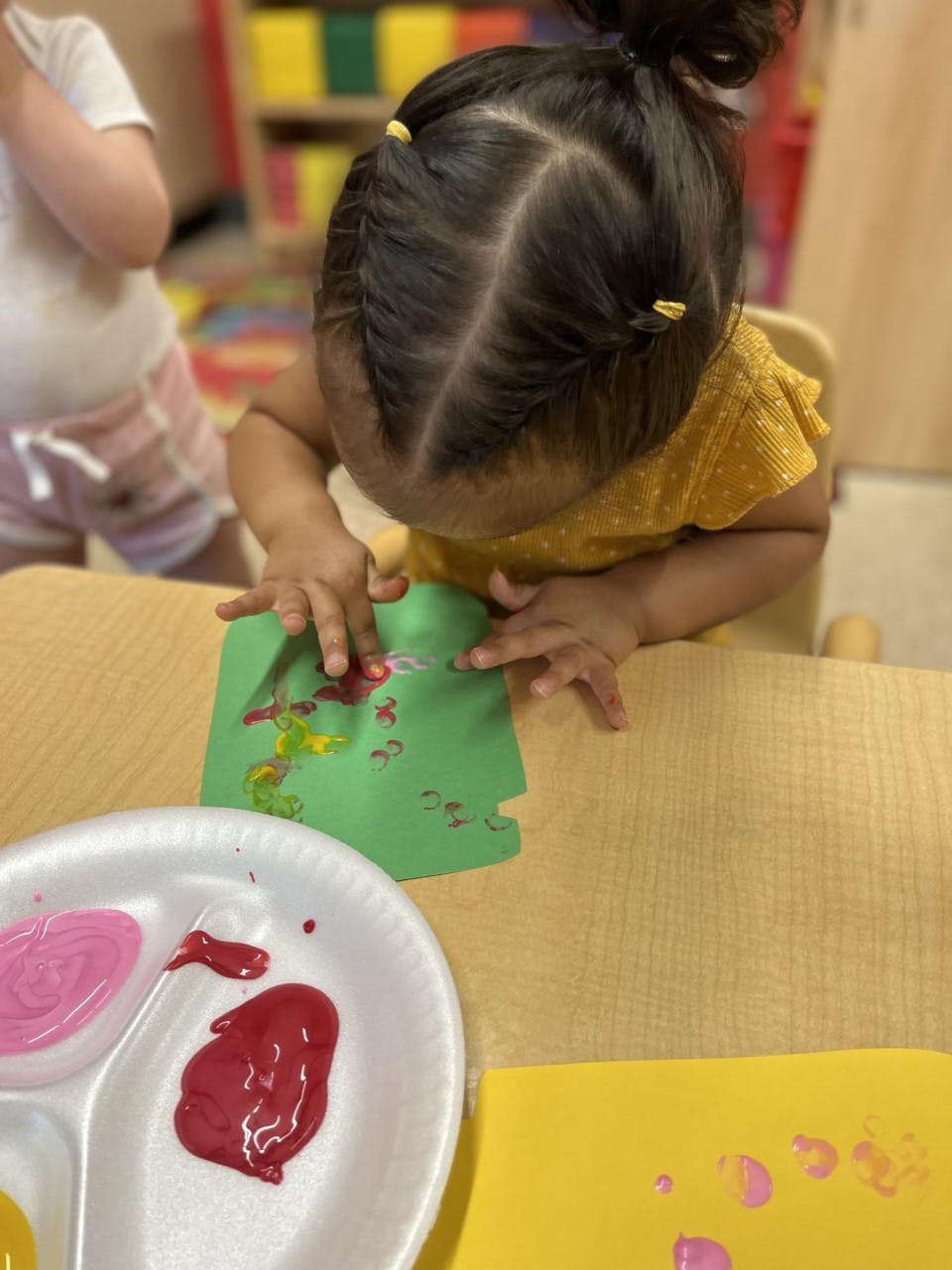 Child painting on green paper