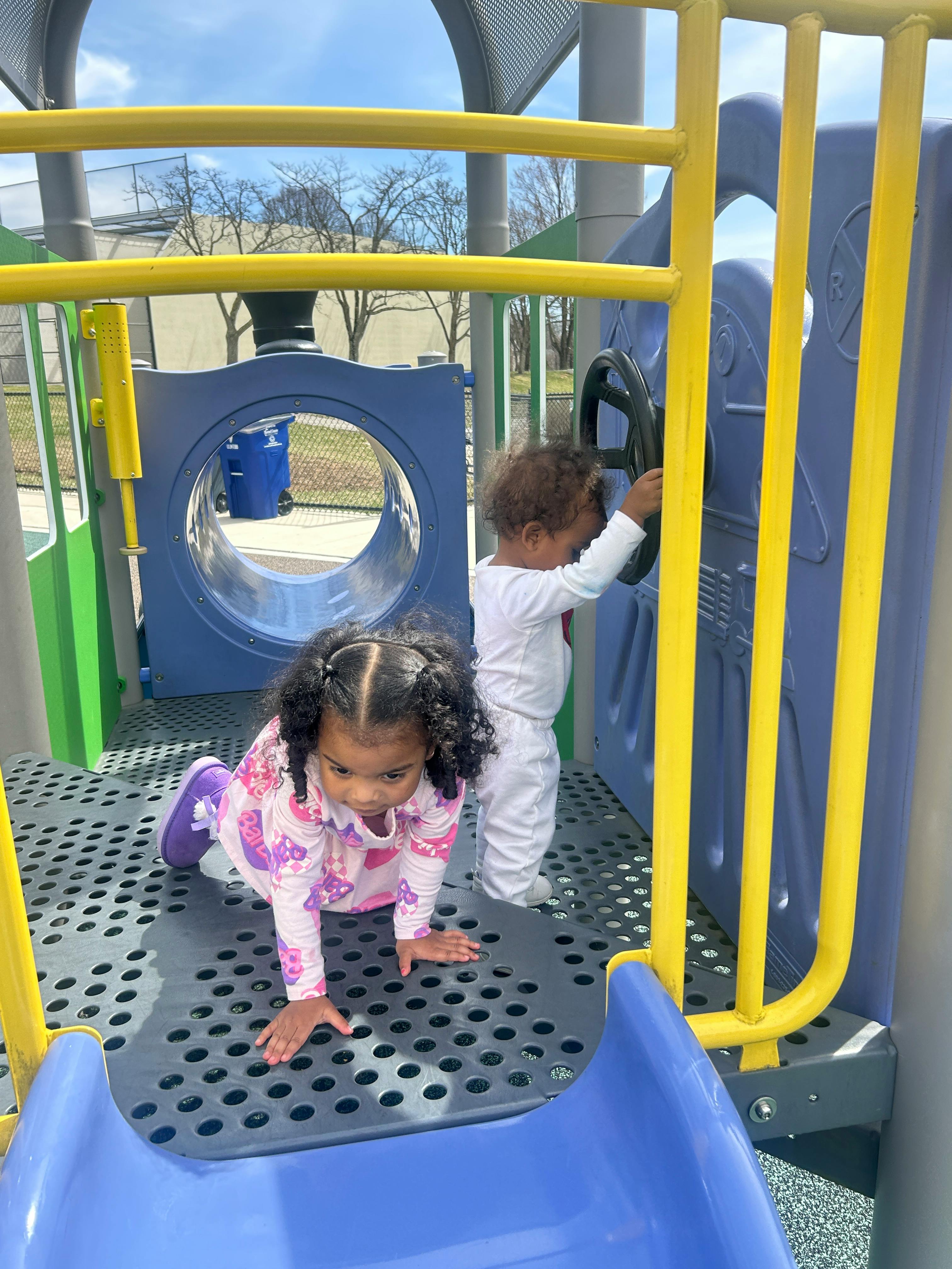 Two children playing on a playground structure