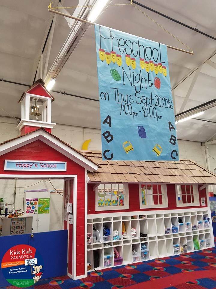 Miniature red schoolhouse with a banner advertising "Preschool Night"