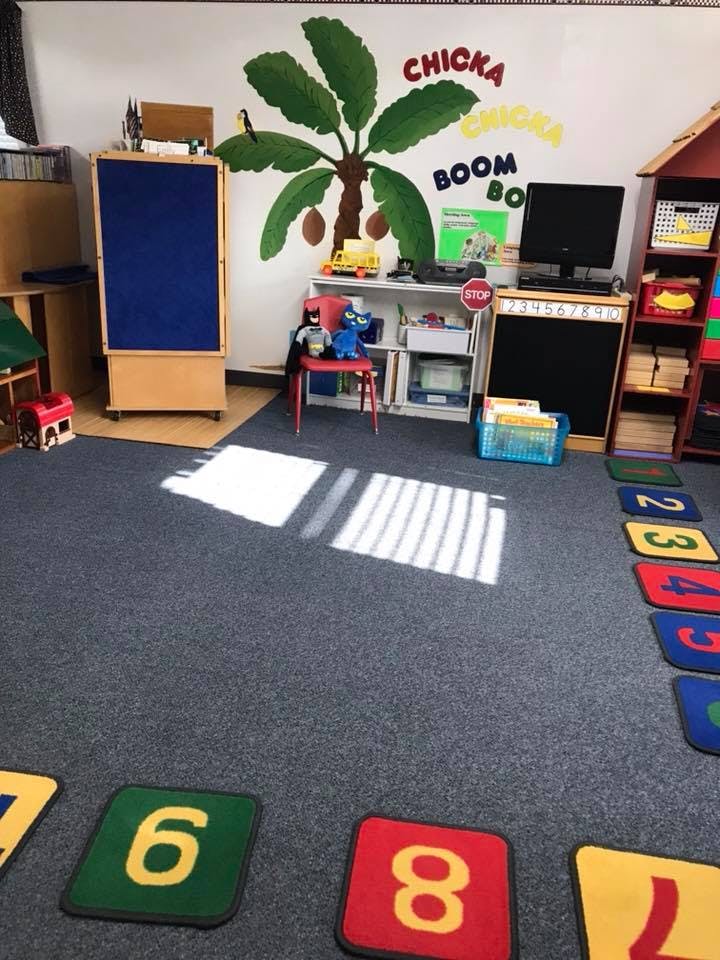 Classroom with a palm tree mural and number mats on the floor